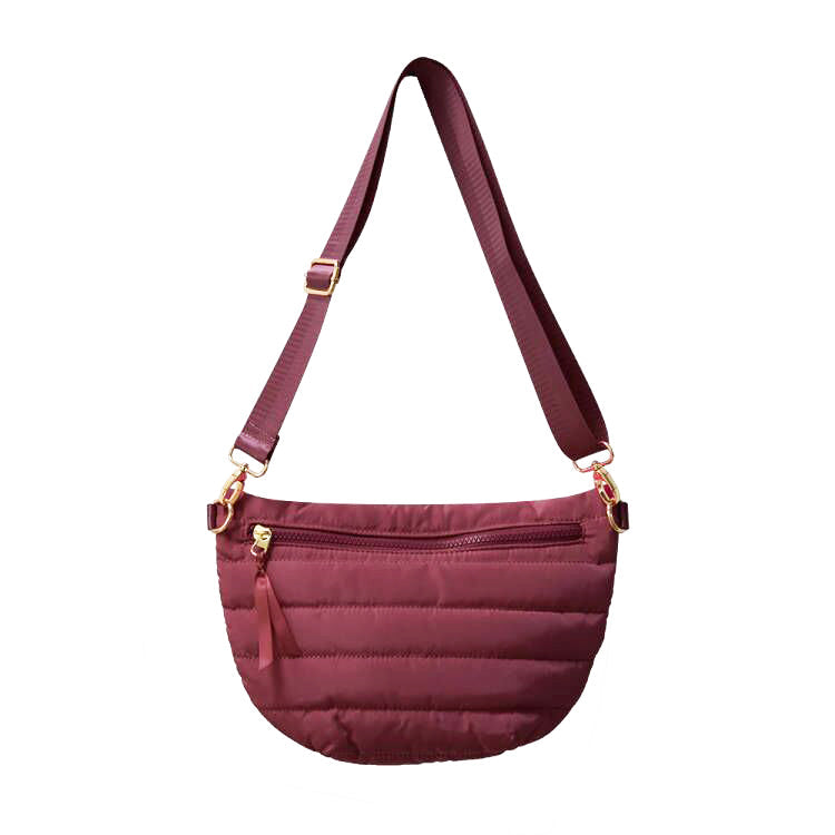 Babs+Birdie Crescent Puffer Sling Bag in quilted nylon with adjustable strap and front zipper pocket, stylish and functional accessory.