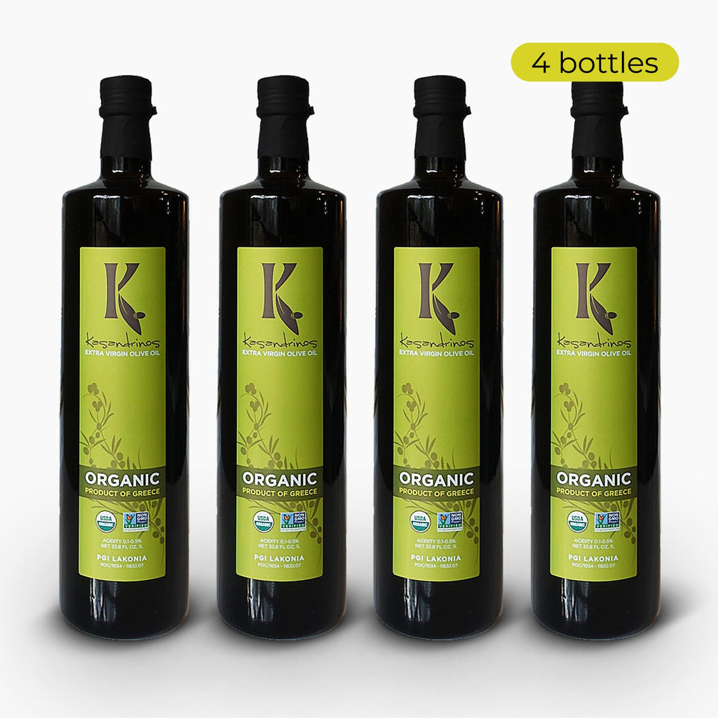 Four 1-liter bottles of Kasandrinos International organic extra virgin olive oil in sleek dark glass bottles.