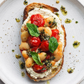 Vegan Fndly recipe image showing butter beans, tomatoes, and tofu “ricotta” on toasted bread for a plant-based dish.