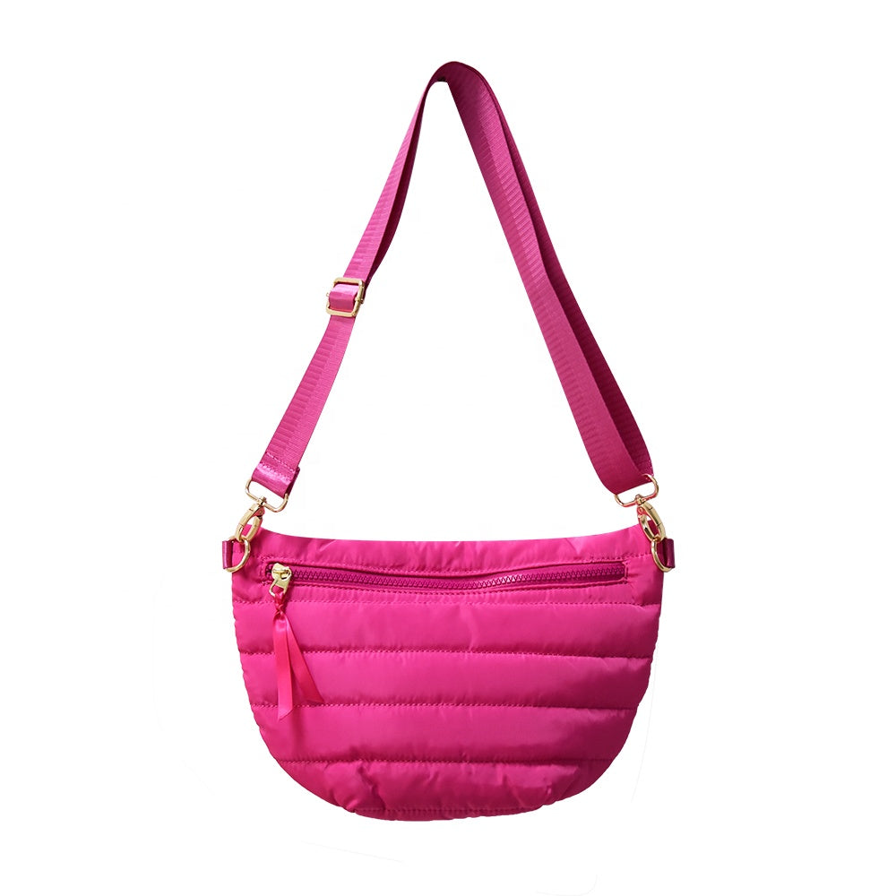 Babs+Birdie Crescent Puffer Sling Bag with quilted design and adjustable strap, shown on a model wearing casual outfit.