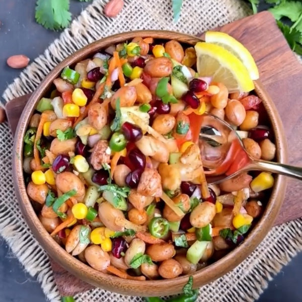 Vegan Fndly high protein peanut salad recipe with fresh vegetables, crunchy peanuts, and colorful ingredients on a white plate.