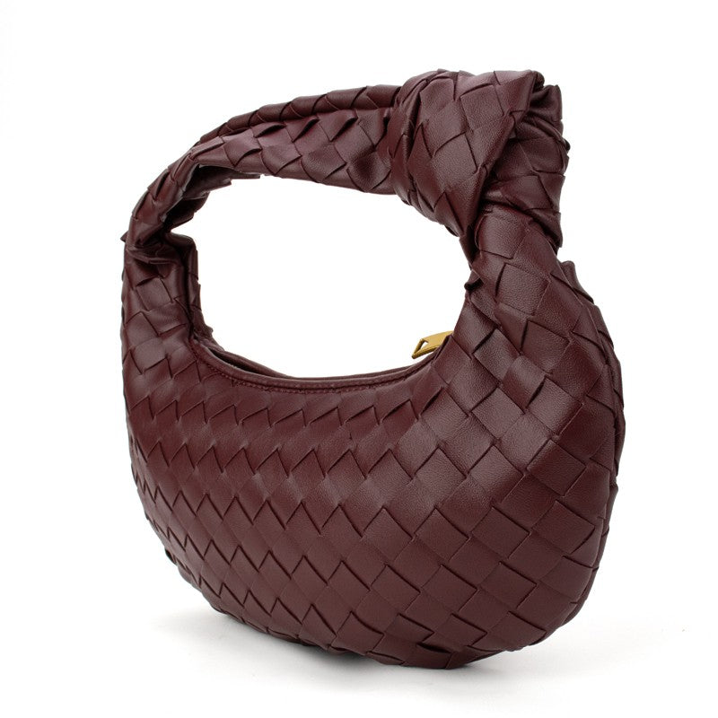 Babs+Birdie The Charlize knotted woven handbag in cranberry color with intricate woven design and knotted handle details.