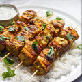 Vegan Fndly turmeric tofu kebabs recipe image showing skewered tofu cubes seasoned with turmeric and herbs, ready for grilling.