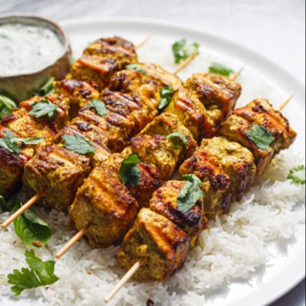 Vegan Fndly turmeric tofu kebabs recipe image showing skewered tofu cubes seasoned with turmeric and herbs, ready for grilling.