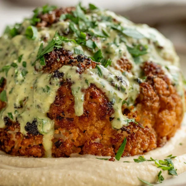 Creamy roasted cauliflower with scallions and date dressing, featured in a Vegan Fndly recipe image showcasing fresh ingredients.