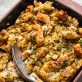 Vegan Fndly vegan stuffing recipe with fresh vegetables, herbs, and seasonings in a baking dish, ready for cooking.